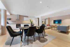 a dining room and living room with a table and chairs at Stryn Apartments - City Center - Modern Suites in Stryn