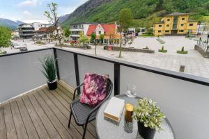 a balcony with a table and a chair with a book at Stryn Apartments - City Center - Modern Suites in Stryn