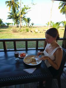 a woman sitting at a table with a plate of food at Origen ZelvaMar BahiaSolano in Bahía Solano +24 photos