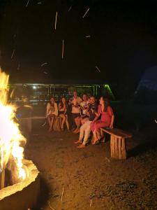 a group of people sitting around a fire at night at Origen ZelvaMar BahiaSolano in Bahía Solano