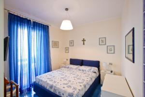 a bedroom with a blue bed and blue curtains at Appartamento Valeria e Andrea in Porto Santo Stefano