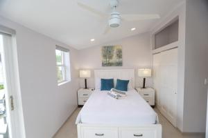 a white bedroom with a white bed and two night stands at 232C South Finger in Jolly Harbour