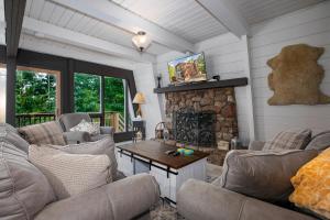 a living room with couches and a stone fireplace at 1186 Fairway Drive: Country Squire in Basye