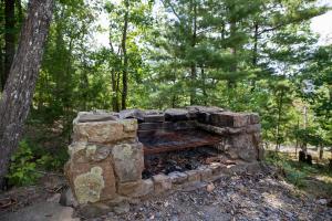 a stone fireplace in the middle of a forest at 1186 Fairway Drive: Country Squire in Basye
