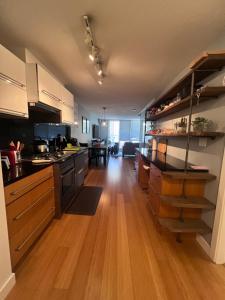 a large kitchen with wooden floors and cabinets and a dining room at Vancouver Condo-Park-Walk to Stadium-Sleeps 4 in Vancouver