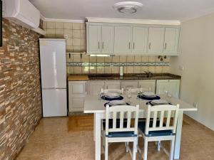 a kitchen with a table with chairs and a refrigerator at Paraiso do Rio Casa T1 in Mondim de Basto