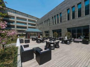 a courtyard with tables and benches in front of a building at NOVOTEL Jinji Lake Suzhou SIP in Suzhou
