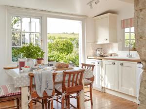 a kitchen with a table and chairs and a window at 3 Bed in Niton oc-73299 in Niton