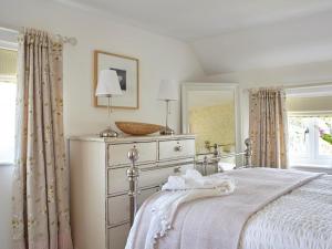 a bedroom with a bed with a dresser and a mirror at 3 Bed in Niton oc-73299 in Niton