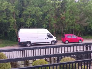 a white van and a red car on a road at Hostel Pod Lasem in Altanka +15 photos