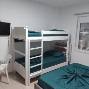 a bedroom with two bunk beds and a television at Private Rooms in Velipojë