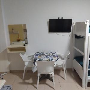 a small room with a table and chairs and a bedroom at Private Rooms in Velipojë