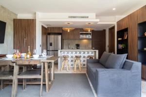 a kitchen and living room with a couch and a table at Ideal Location with Cenote Pools Gym Restaurant in Tulum