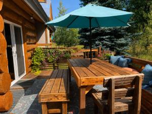 a wooden table with an umbrella on a patio at Pinedale Cabin in McCall