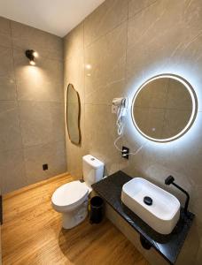a bathroom with a toilet and a sink and a mirror at Studio Shogun Vista, Ar, Vaga 5 min do mar in Ilhabela