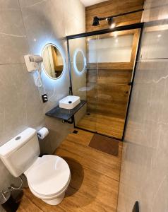 a bathroom with a toilet and a sink and a shower at Studio Shogun Vista, Ar, Vaga 5 min do mar in Ilhabela
