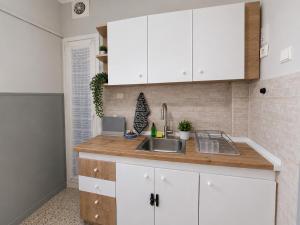 a kitchen with white cabinets and a sink at Karma Seaside Apartment in Perea