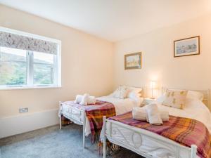 two beds in a room with a table and a window at 2 Bed in Monmouth oc-93650 in Trelleck