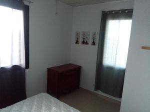 a bedroom with a bed and a dresser and two windows at F2 bien situe in Oran
