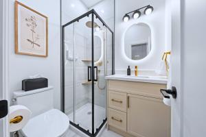 a bathroom with a shower and a toilet and a sink at Casa Hotels Gerrard Private Basement Suite in Toronto