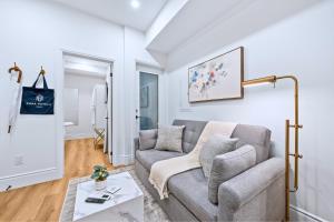a living room with a couch and a table at Casa Hotels Gerrard Private Basement Suite in Toronto +13 photos