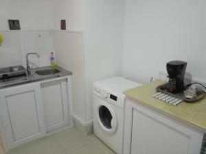 a kitchen with a washing machine and a sink at F2 bien situe in Oran