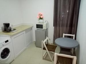 a kitchen with a washing machine and a microwave at F2 bien situe in Oran +4 photos