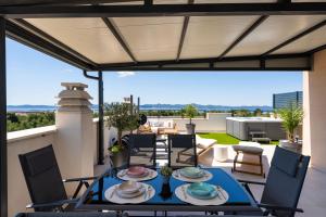 a patio with a table and chairs on a balcony at Sky Lounge & More - Rooftop Wellness & Gym in Zadar