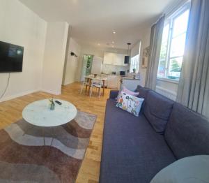a living room with a blue couch and a table at Central City Apartment B in Nyköping