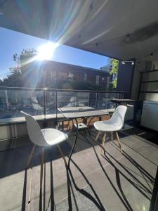 a table and chairs on a balcony with the sun at Vancouver Condo-Park-Walk to Stadium-Sleeps 4 in Vancouver