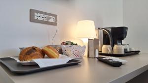 a table with a tray of bread and a coffee maker at Venti del Sud in Vieste