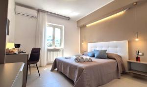 a bedroom with a bed and a desk and a window at Venti del Sud in Vieste