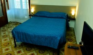a bedroom with a bed with a blue comforter at Alla Cattedrale - Locazione Turistica in Sulmona
