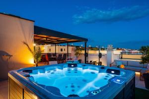 a jacuzzi tub on a balcony at night at Sky Lounge & More - Rooftop Wellness & Gym in Zadar