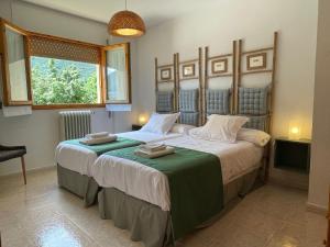 a bedroom with two beds and a window at Tena Biescas Tourist Home in Biescas +50 photos
