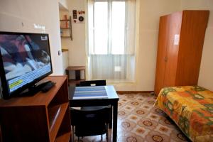 a hotel room with a television and a bed at Alla Cattedrale - Locazione Turistica in Sulmona