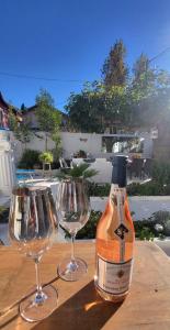 a bottle of wine and two wine glasses on a table at Appartement Chaleureux avec Jardin proximité Métro in Marseille