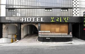 a hotel with a sign on the side of a building at Hotel Barley Field Seoknam in Incheon