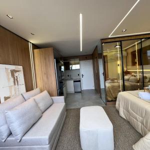 ein Wohnzimmer mit Sofa und Bett in der Unterkunft Royale Studio in Criciúma