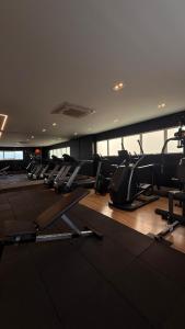 ein Fitnessstudio mit Reihen von Laufbändern und Ellipsentrainern in der Unterkunft Royale Studio in Criciúma