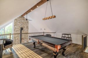 a pool table in a room with a balcony at Käbane Nova - La Chaleureuse in Baie-Saint-Paul