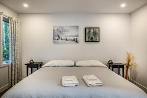 a bedroom with a bed with two towels on it at Käbane Nova - La Chaleureuse in Baie-Saint-Paul