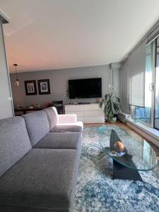 a living room with a couch and a glass table at Vancouver Condo-Park-Walk to Stadium-Sleeps 4 in Vancouver
