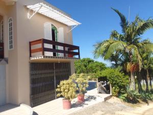 a house with a gate and palm trees at Quartos na Montanha in Siderópolis +9 photos
