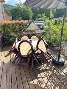 a table with two chairs and an umbrella on a deck at Gîtel'harmonie2 in Fraize