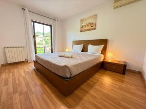 a bedroom with a bed with two lamps on it at Casa Terra Nova - Gerês in Terras de Bouro +69 photos