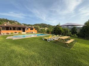 a yard with a picnic table and an umbrella at Casa Terra Nova - Gerês in Terras de Bouro