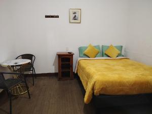 a bedroom with a bed and a table and a chair at linda casona mancora in Santiago