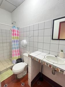 a white bathroom with a toilet and a sink at Hostal Vacaciones Nicas in León +76 photos