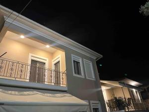 a white house with a balcony at night at S&E home in Nikiana